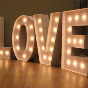 Las letras gigantes 'LOVE' de Animus Discotecas crean un ambiente romántico en un espacio interior para celebraciones de boda.