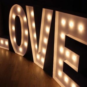 Las letras gigantes 'LOVE' de Animus Discotecas resaltan sobre un suelo oscuro, proporcionando una iluminación suave y romántica para eventos nocturnos.