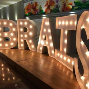 Letras gigantes 'BRAIS' iluminadas por Animus Discotecas en un mostrador, ofreciendo un enfoque luminoso y festivo para la decoración del evento.