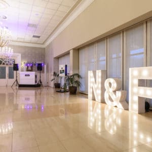 Animus Discotecas presenta letras gigantes iluminadas 'N&F' para eventos, creando un ambiente perfecto en una boda elegante.