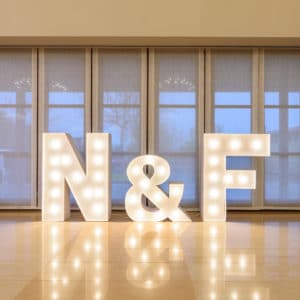 Letras gigantes 'N&F' de Animus Discotecas resaltan en un salón de eventos, ideales para celebraciones memorables.