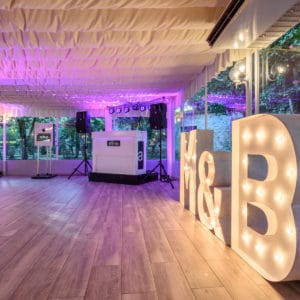 Letras gigantes para bodas 'M&B' brillando en un entorno de evento al aire libre, capturando la esencia de la celebración.