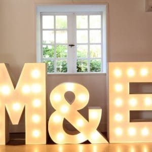 Iluminación acogedora de letras para boda 'M&E' destacando en un espacio luminoso, perfecto para celebraciones nupciales.