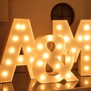 Decoración de letras gigantes para eventos con iluminación cálida 'A&M' para una boda elegante por Animus Discotecas.